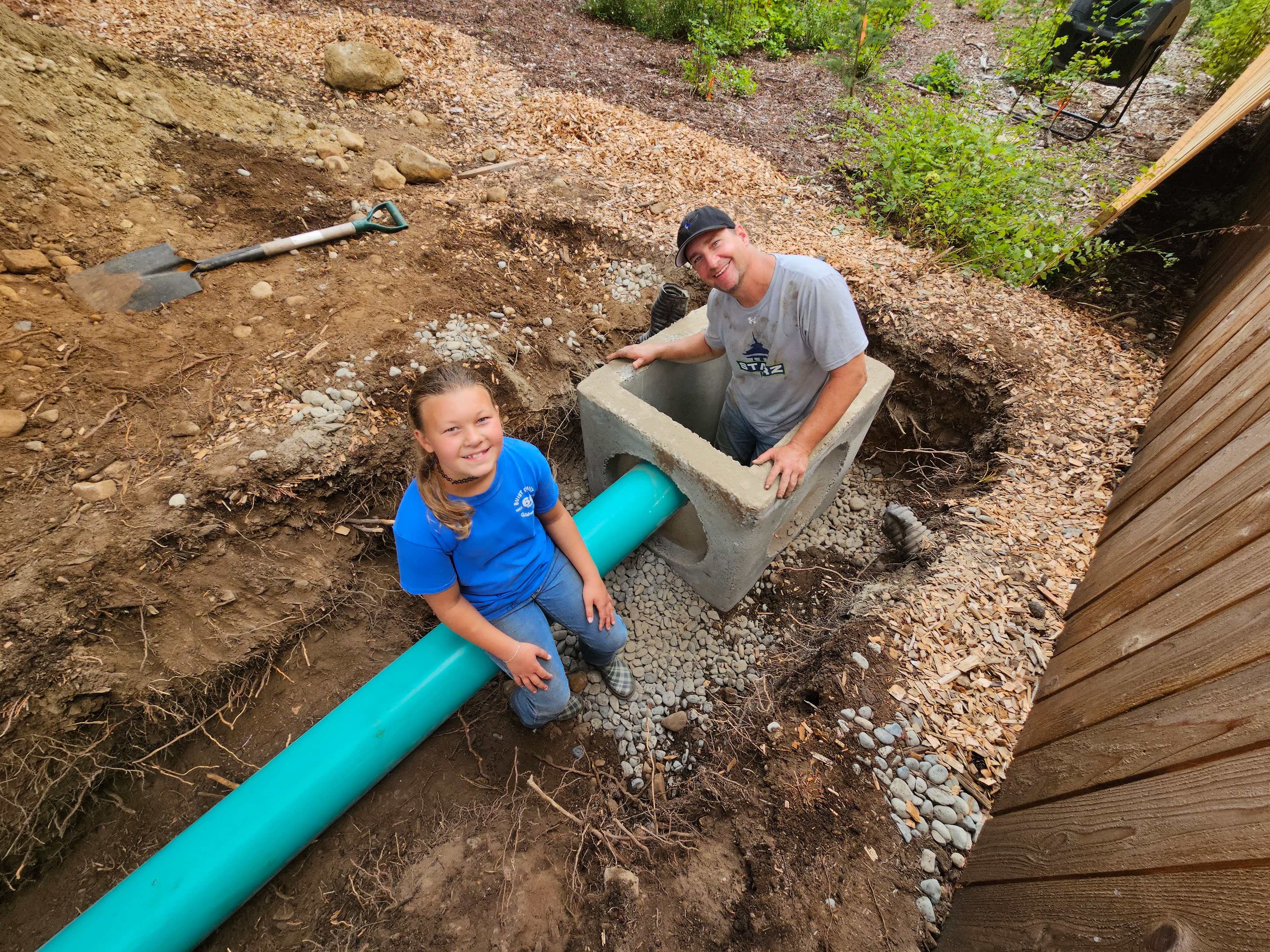 children playing in a catchment basin trench